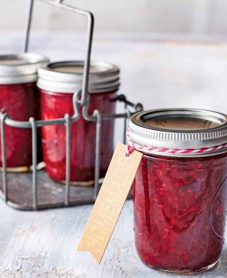 mason jar filled with red jam with a kraft paper tag