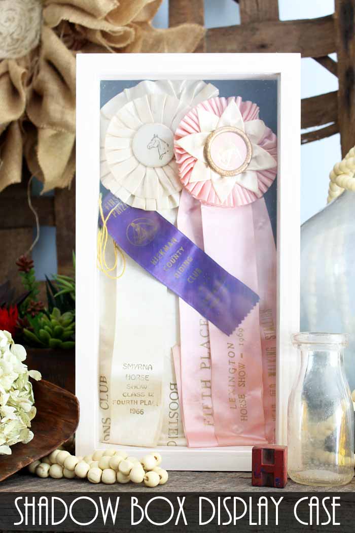 Shadow box with white, light pink and purple ribbons 