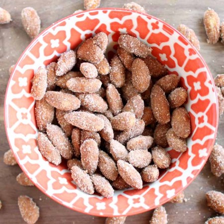 Orange bowl of spiced Almonds on wooden table