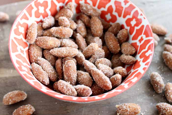 A close up of pumpkin pie spiced almonds in an orange and white bowl