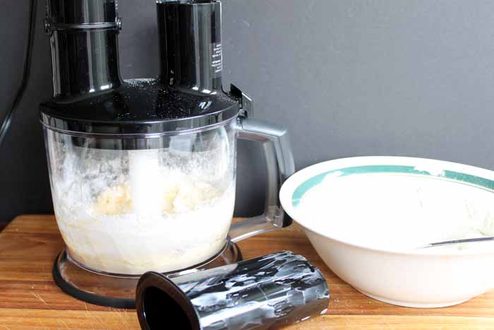 braun food processor beside white bowl with green stripe