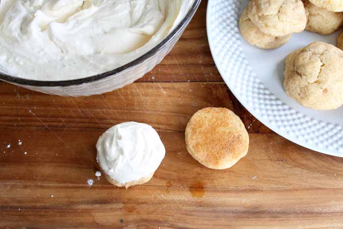 A wooden table topped with plates of Snickerdoodle and Buttercream cookies