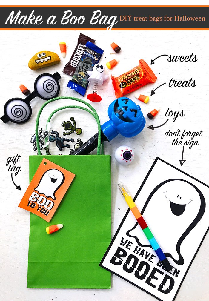 green felt bag with ghost tag with assorted Halloween treats on white background