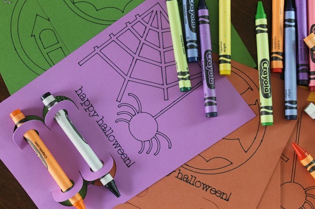 purple halloween coloring sheet on top of orange paper with crayons on top