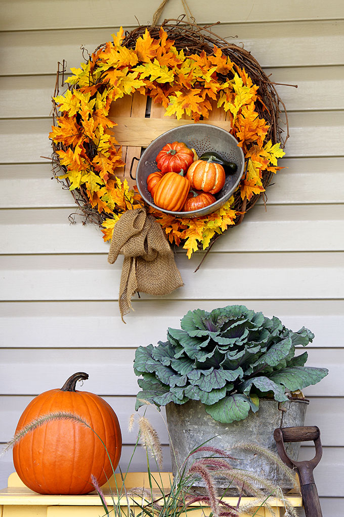 fall wreath with leaves and basket of gourds with pumpkins