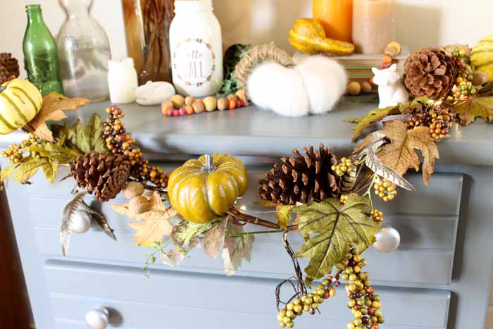 pumpkin pinecones and leaves garland on a blue table