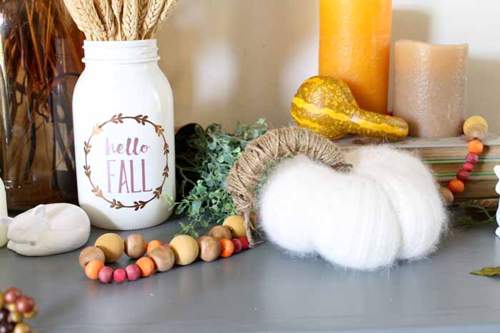fuzzy white pumpkin with multi colored wooden bead garland