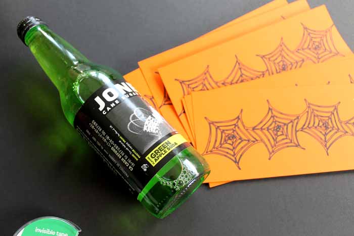 orange Halloween bottle labels with green soda bottle on black background