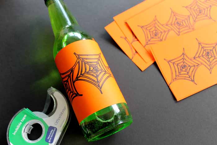 tape, green bottled drink with orange spider web label and additional labels