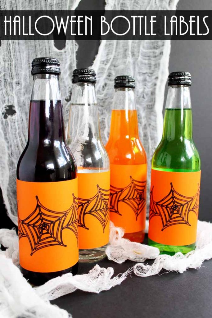 glass bottled drinks with orange labels in front of spider web