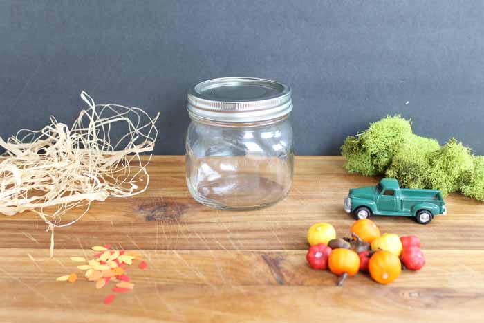empty mason jar with fall pieces on a wooden board