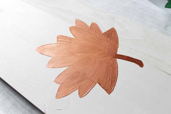painted metallic brown leaf on unfinished wood