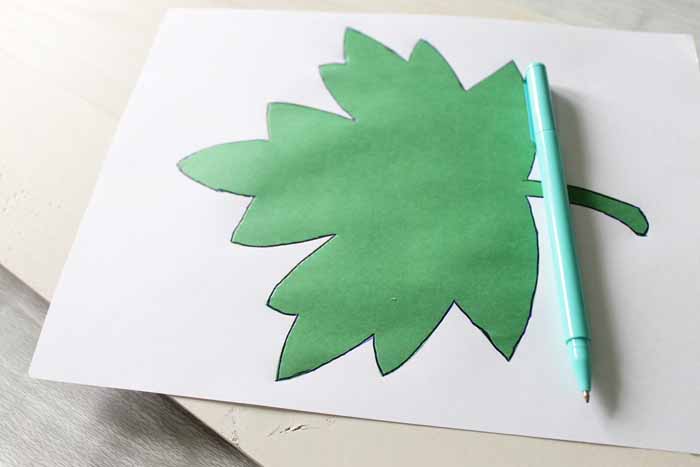 green leaf on white paper on top of unfinished wooden