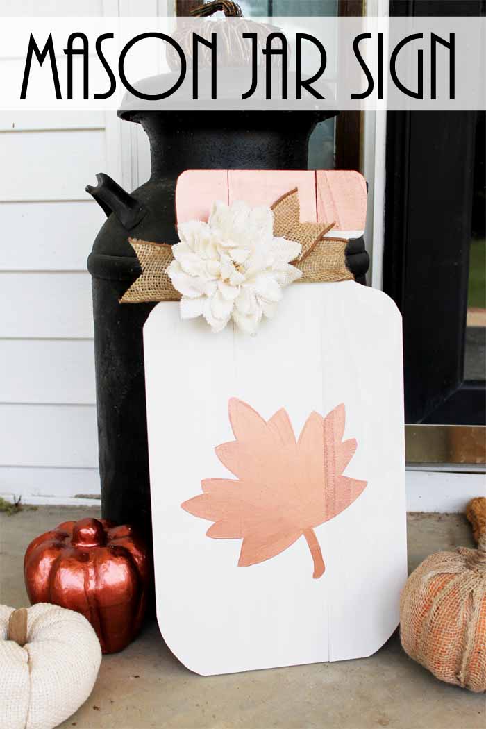 large wooden cut out of a mason jar with leaf and flower on a fall porch