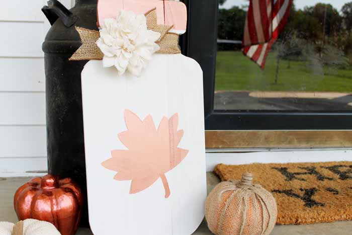 wooden mason jar sign with flower and burlap pumpkin on porch