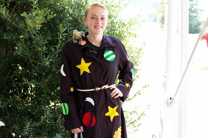 A person standing next to a tree wearing a Miss Frizzle costume