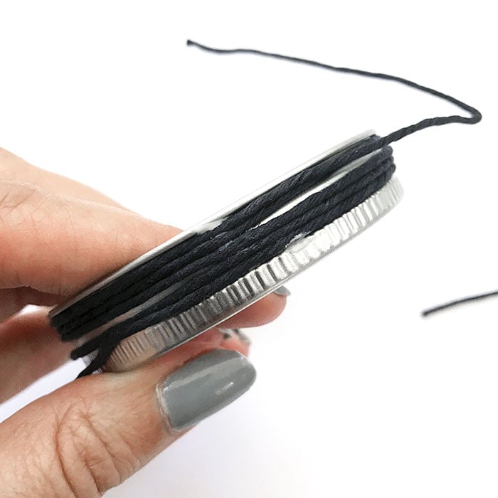 black thread tied around mason jar lid