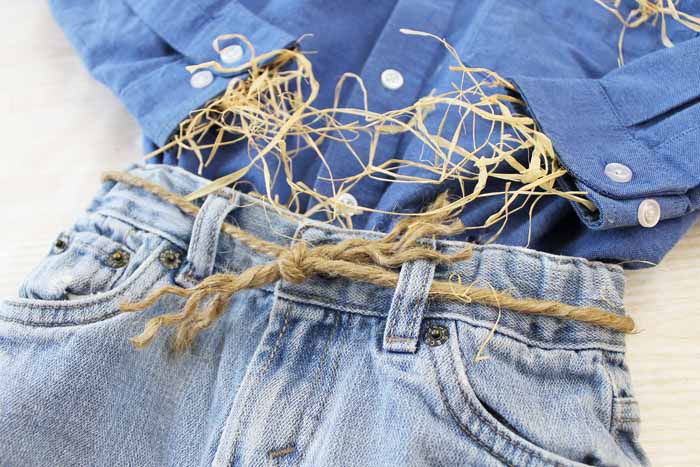 tying jeans with jute rope and putting hay in a shirt sleeve 