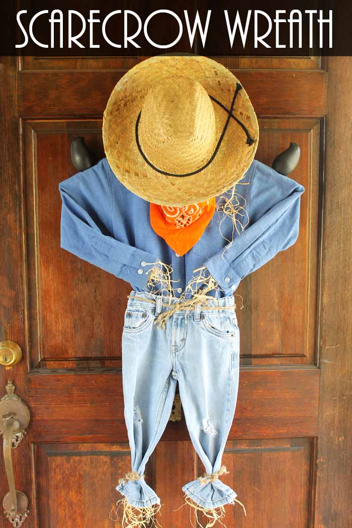 scarecrow wreath on a wooden front door with orange bandana