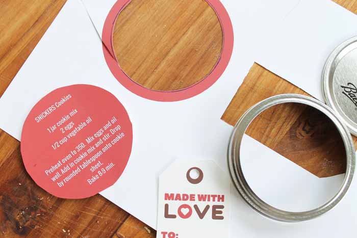 mason jar lids with printable tags on a wooden cutting board