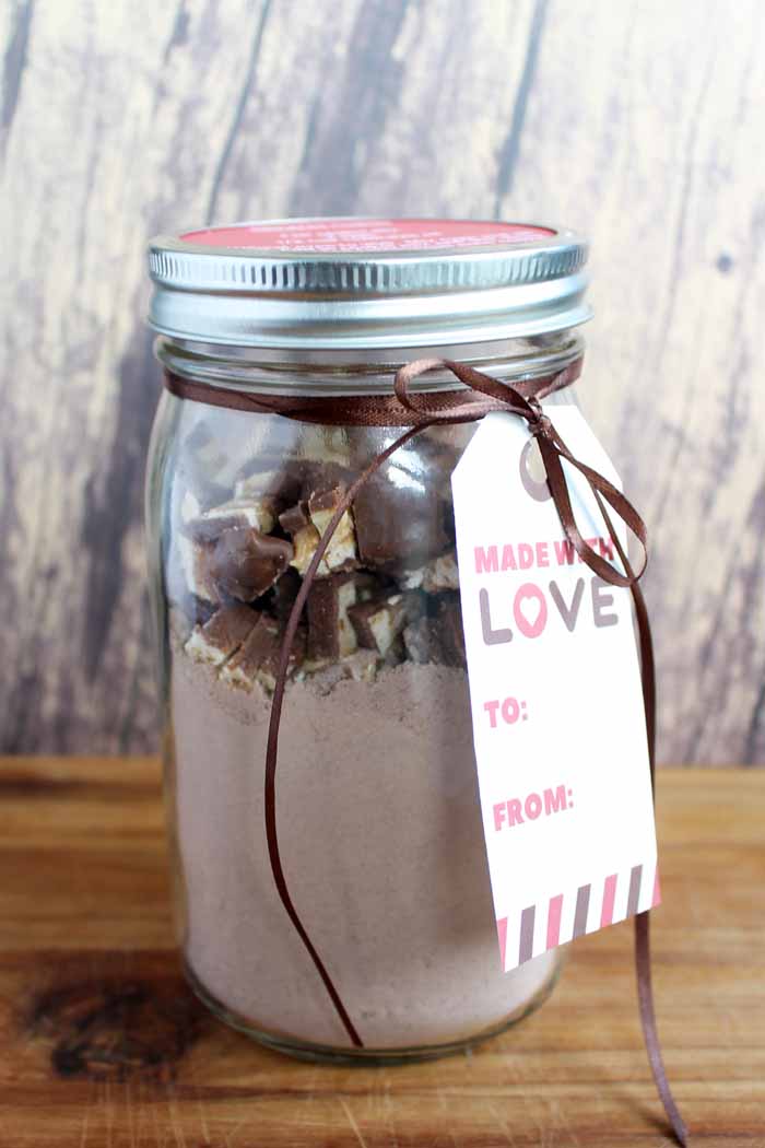 A close up of a mason jar cookie mix gift of snickers cookies