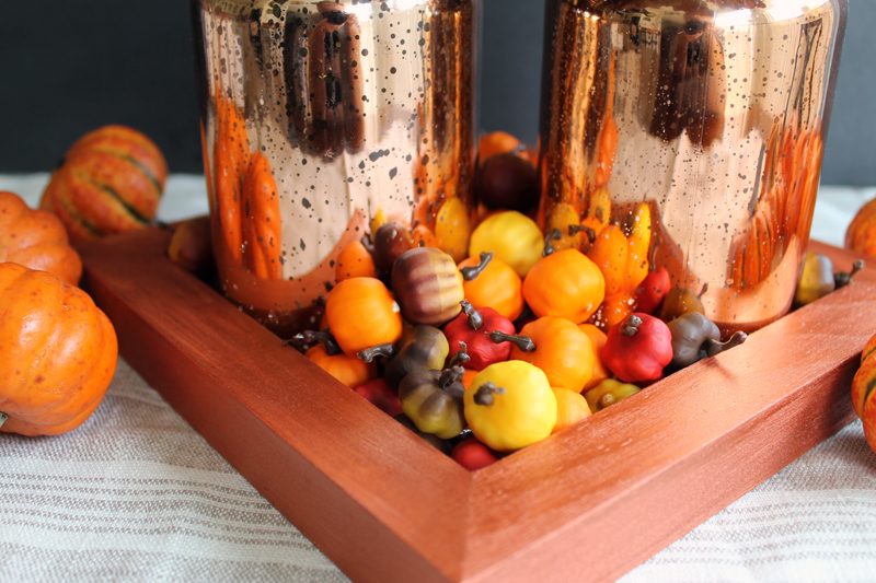 Orange tray with metallic mason jars and small decorative pumpkins