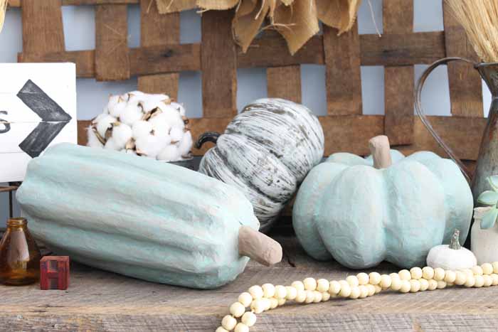 farmhouse display of painted pumpkins, cotton and wooden beads