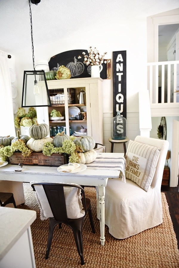 farmhouse style table with pumpkin centerpiece