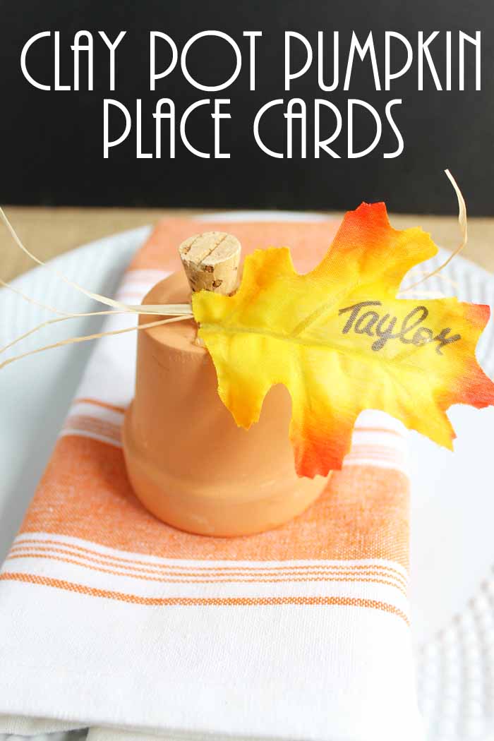 A close up of terra cotta pumpkin with a handwritten name on a leaf for a fall placecard