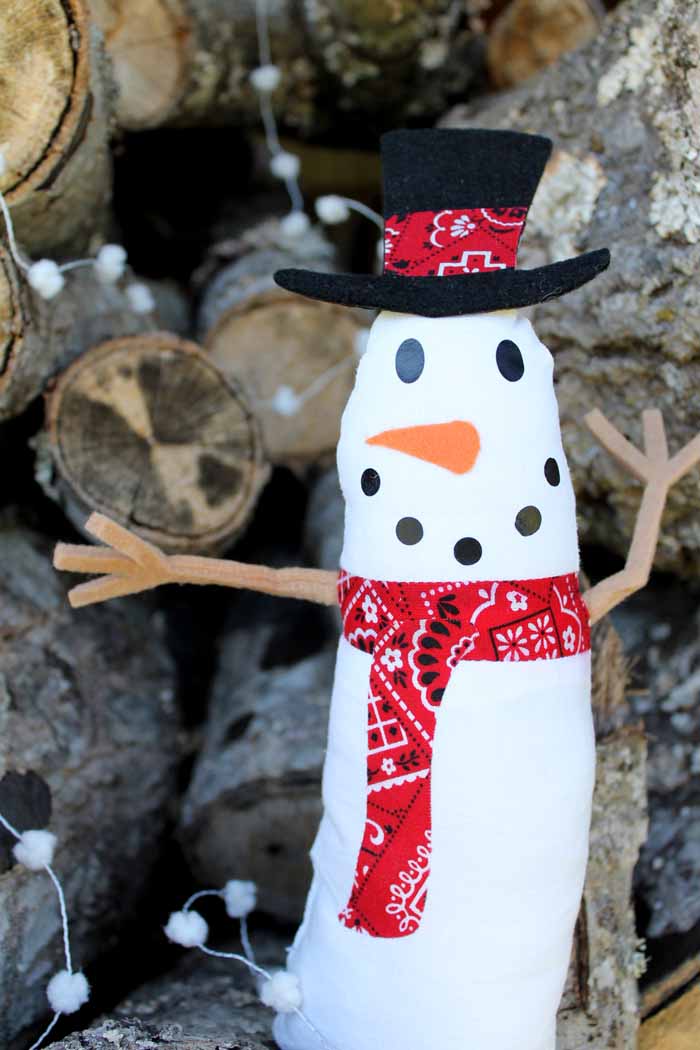 close up of a snowman craft in front of a wooden backdrop