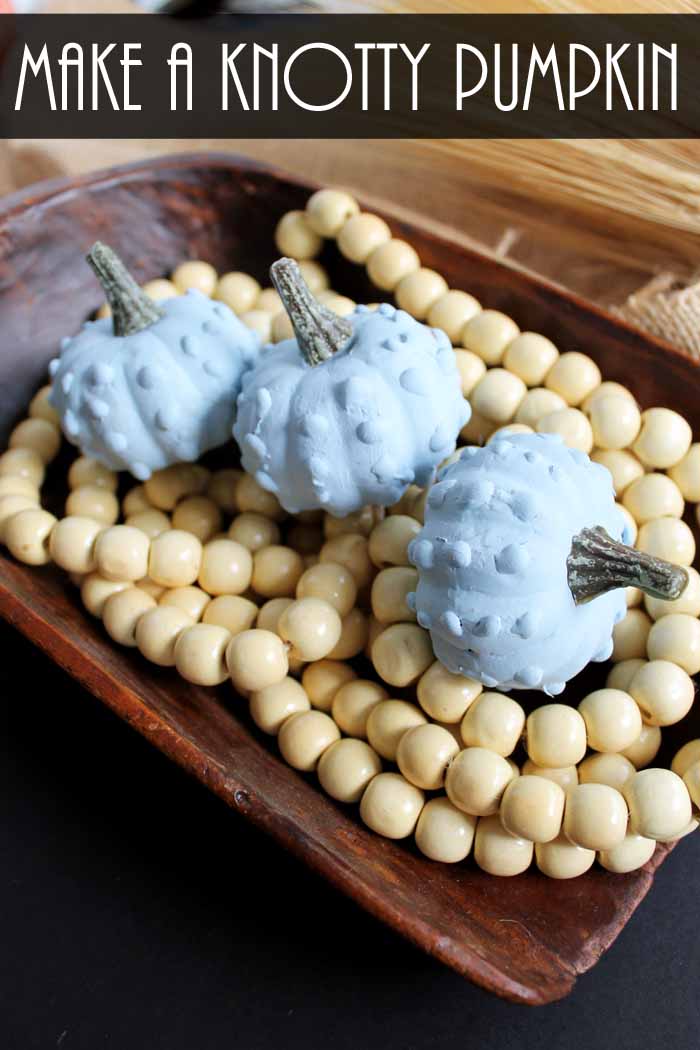 light blue decorative gourds on wooden beads in a bread bowl for easy fall decor