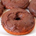 A close up of an iced chocolate cake donut