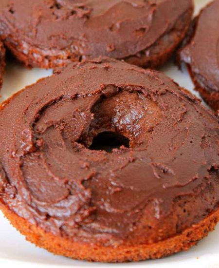 A close up of an iced chocolate cake donut