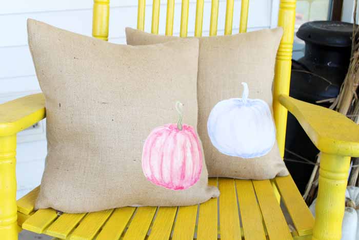 Watercolor pumpkin burlap pillows on a yellow rocking chair