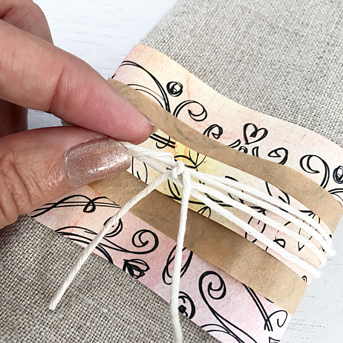 adding twine to a paper napkin ring