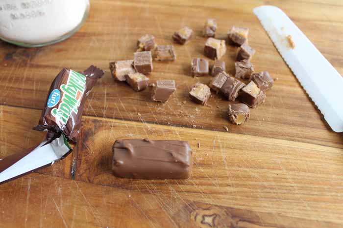 Milky way bar halved and cut into quarter pieces, atop wooden table