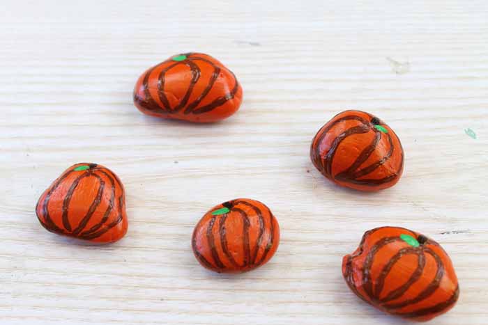 painted rocks that look like pumpkins for a diy tic tac toe game 