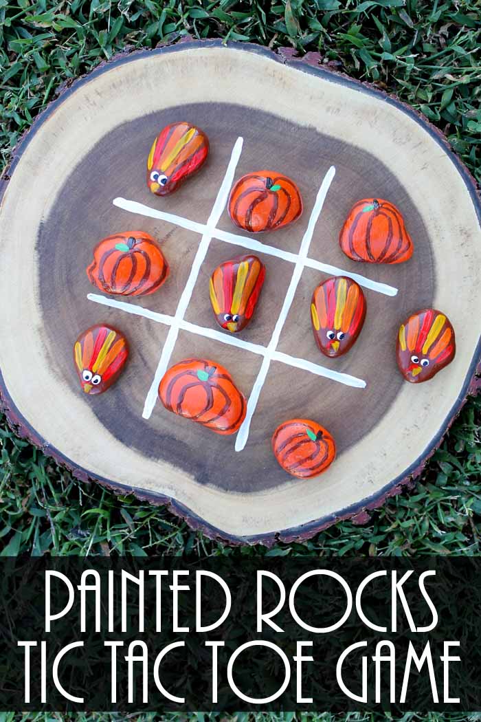 wood slice painted rocks tic tac toe game in the grass