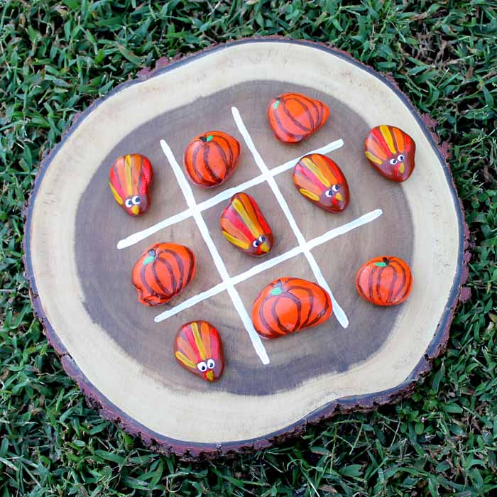 Wood slice with painted rocks for a Thanksgiving tic tac toe game