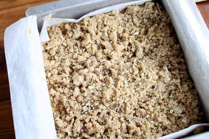 adding crumble to the top of the mixture in the pan