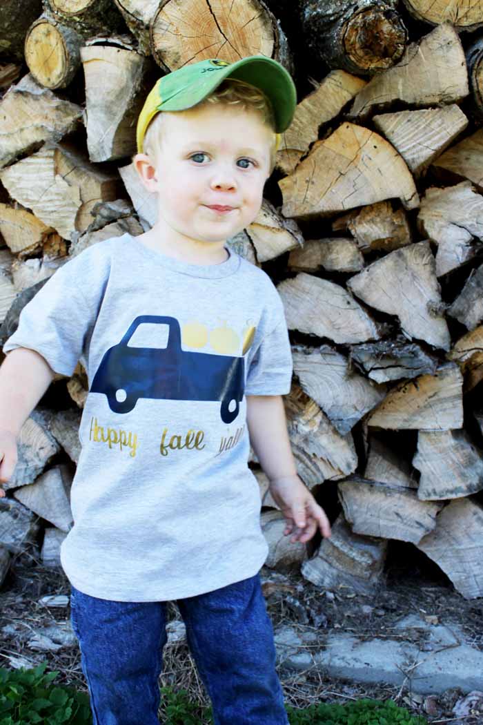 little boy wearing a truck with pumpkins on a shirt
