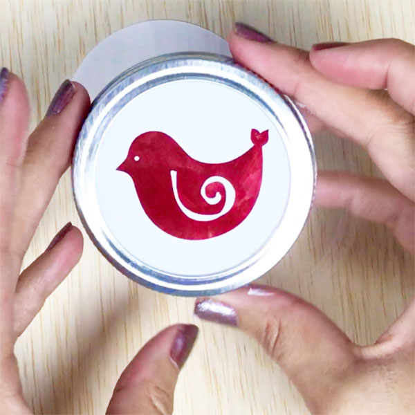 mason jar lid with christmas bird inside