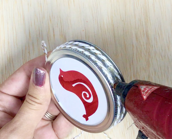 adding twine around a mason jar lid with glue