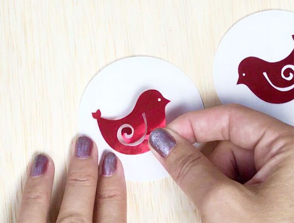 adding red vinyl bird to a white paper circle