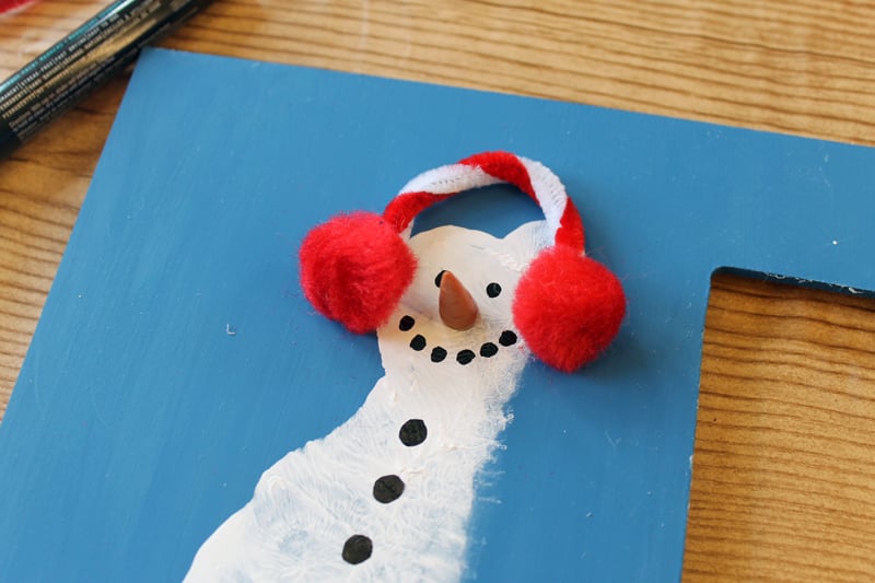 adding earmuffs to a footprint snowman