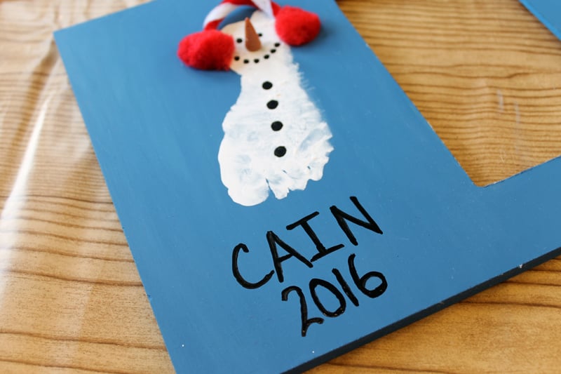 DIY Picture Frame adding name and year in black paint on a photo frame