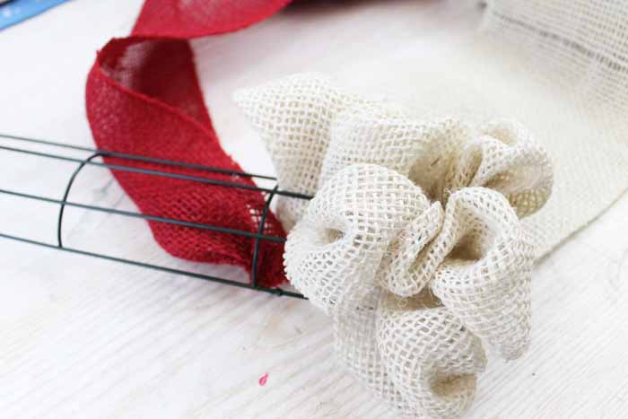 starting red burlap ribbon onto a wire wreath form