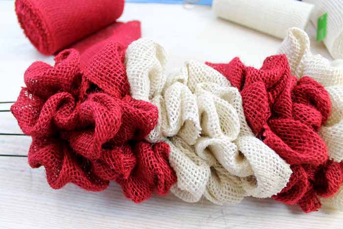 Learn how to make your own DIY candy cane wreath with these step by step instructions. Add this whimsical DIY Christmas wreath to your home! burlap ribbon wreath close up