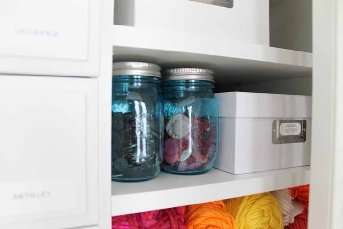 mason jars with buttons on a shelf