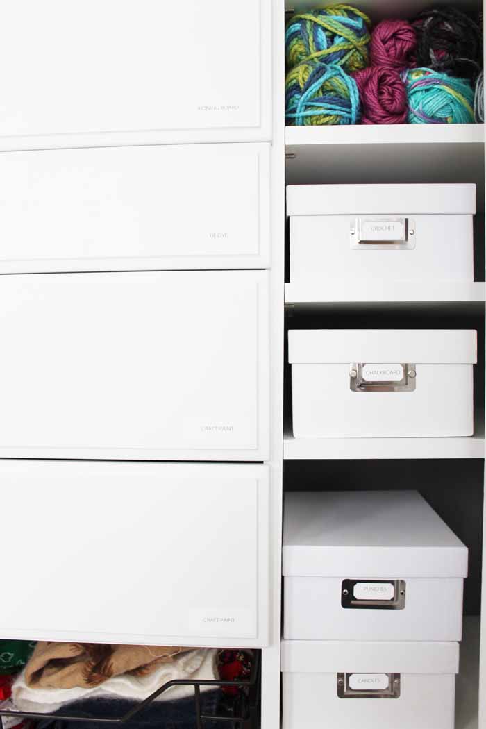 white storage boxes with craft supplies on shelves